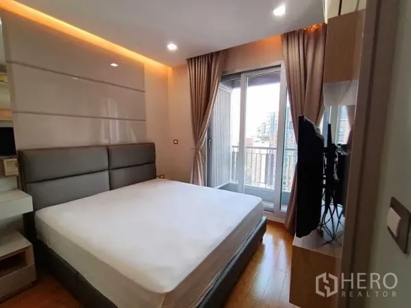 公寓 出租在Ratchathewi, Bangkok - 明亮卧室配大床与阳台门，城市景观，靠近Phetchaburi地铁站的公寓。