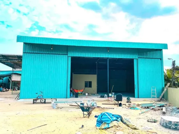 货栈 出租在Sai Mai, Bangkok - 青绿色金属外墙仓库正立面，超宽推拉门与前场空地。