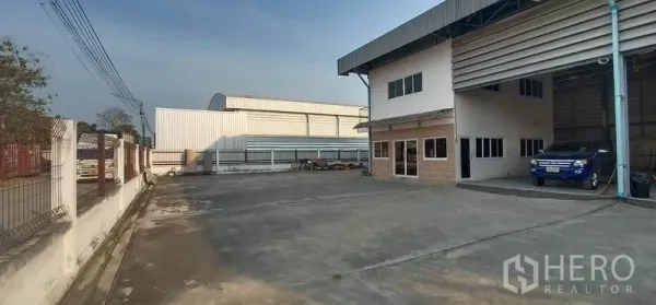 货栈 出租在Khlong Luang, Pathum Thani - 宽阔混凝土院场与连接的两层办公室，适合卡车停放。
