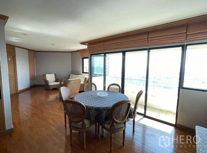 Condominium for rent - Dining area with round table beside floor-to-ceiling sliding doors to the balcony.