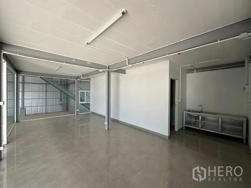 Factory for rent in Wang Noi, Phra Nakhon Si Ayutthaya - Bright office room with tiled floor, glass partitions, and a small sink within the warehouse.