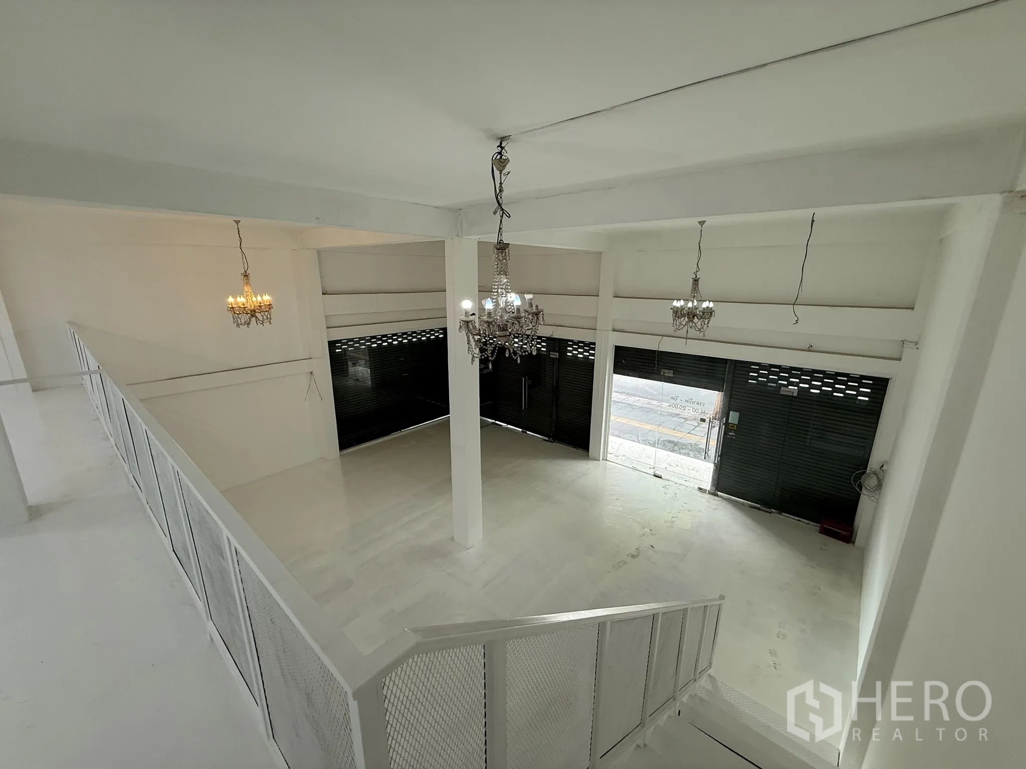Shophouse for rent in Khlong Toei, Bangkok - View from the mezzanine overlooking the ground-floor sales area and roller shutters.