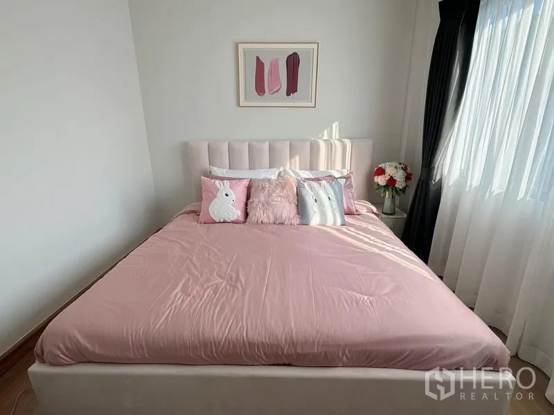 Detached House for rent or sale in Bang Phli, Samut Prakan - Sunlit pink-themed bedroom with upholstered headboard and sheer curtains.