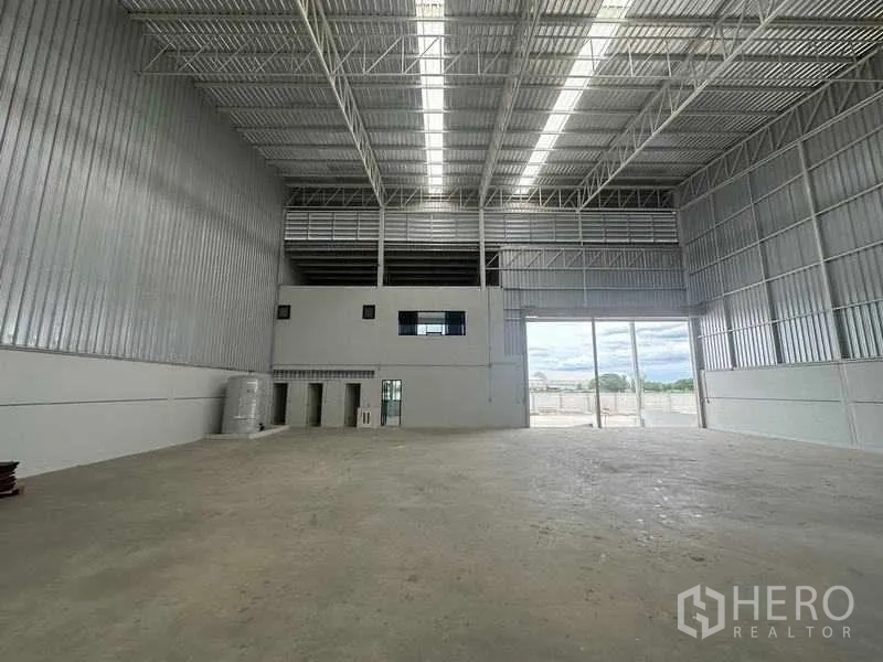 Factory for rent in Wang Noi, Phra Nakhon Si Ayutthaya - Expansive work floor with a concrete column and ventilation panels near the loading door.