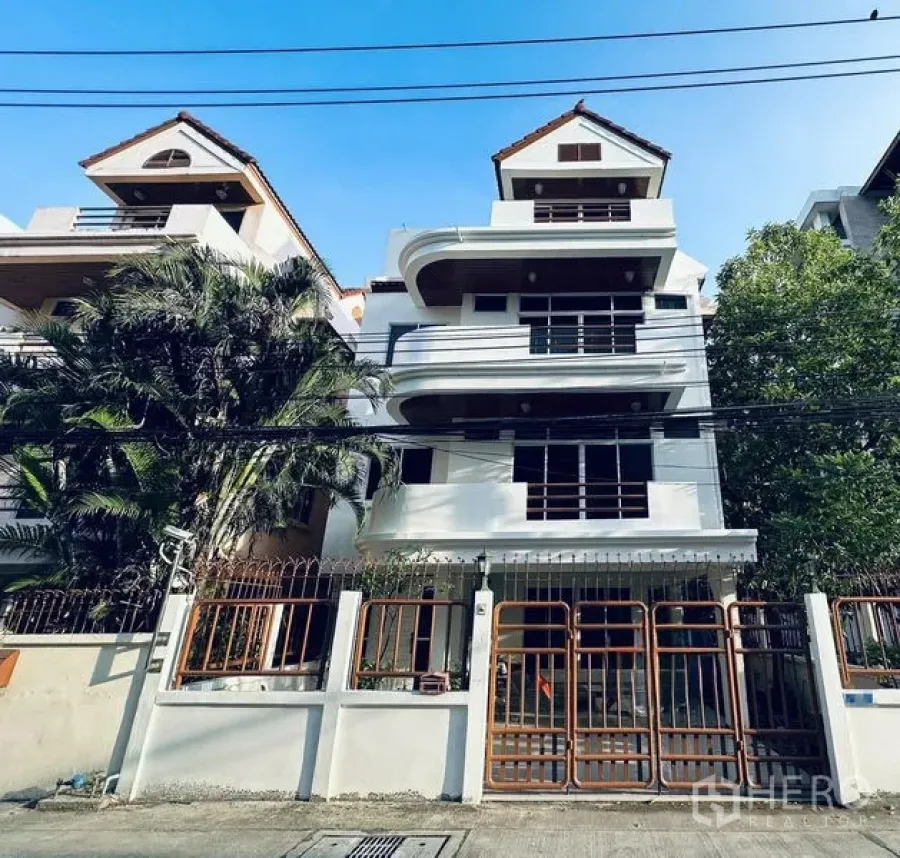 独立式住宅 出租在Watthana, Bangkok - 多层独栋外立面，带阳台与庭院铁门。