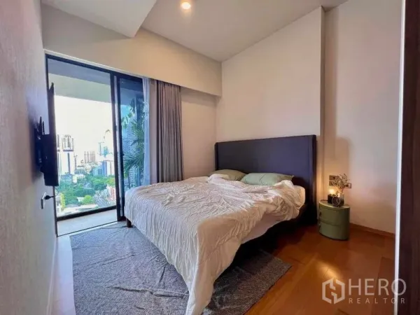 Condominium for rent - Bedroom with double bed opening to a balcony and Bangkok skyline views.