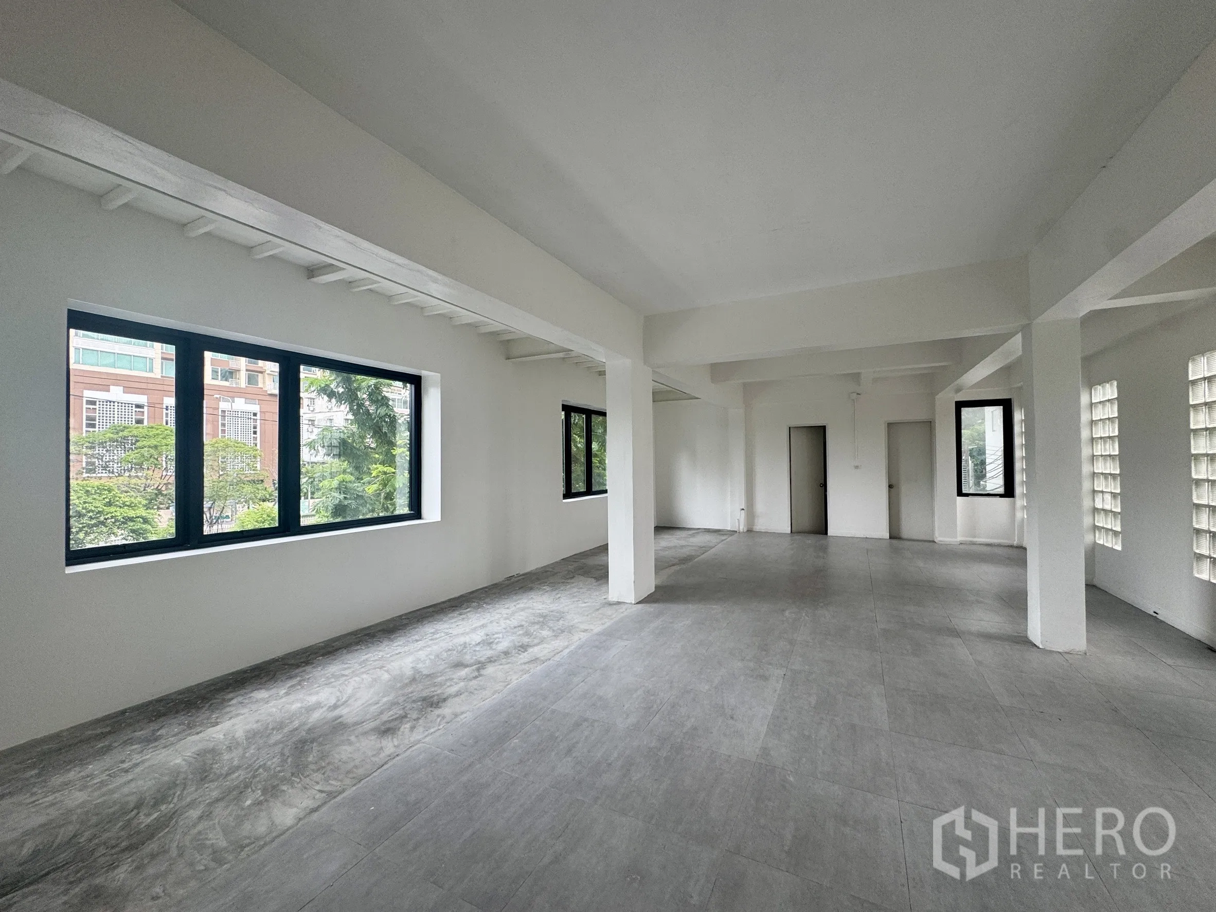 办公空间 出租在Sathon, Bangkok - 开放式楼层另一角度，灰色地砖与转角窗。