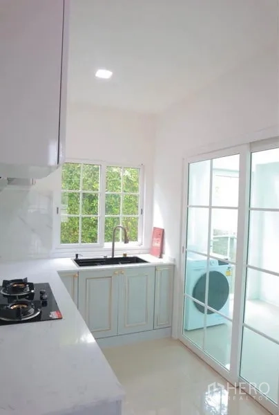 Detached House for rent in Bang Phli, Samut Prakan - Kitchen sink area with sliding doors to laundry and garden view.