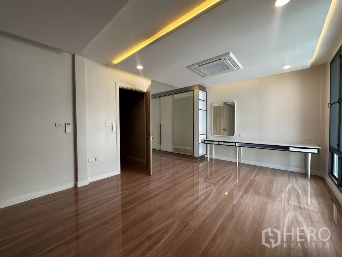 Townhouse for rent in Watthana, Bangkok - Spacious bedroom with cove lighting and an extra-long work desk.