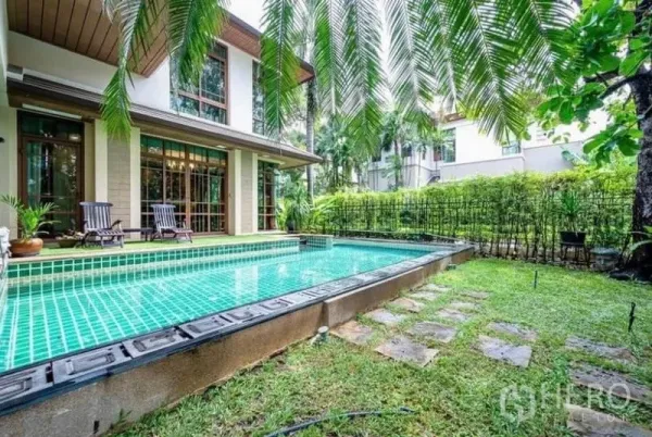 独立式住宅 出租在Khlong Toei, Bangkok - 房后私家绿瓷砖游泳池，旁有景观花园与休闲木平台。