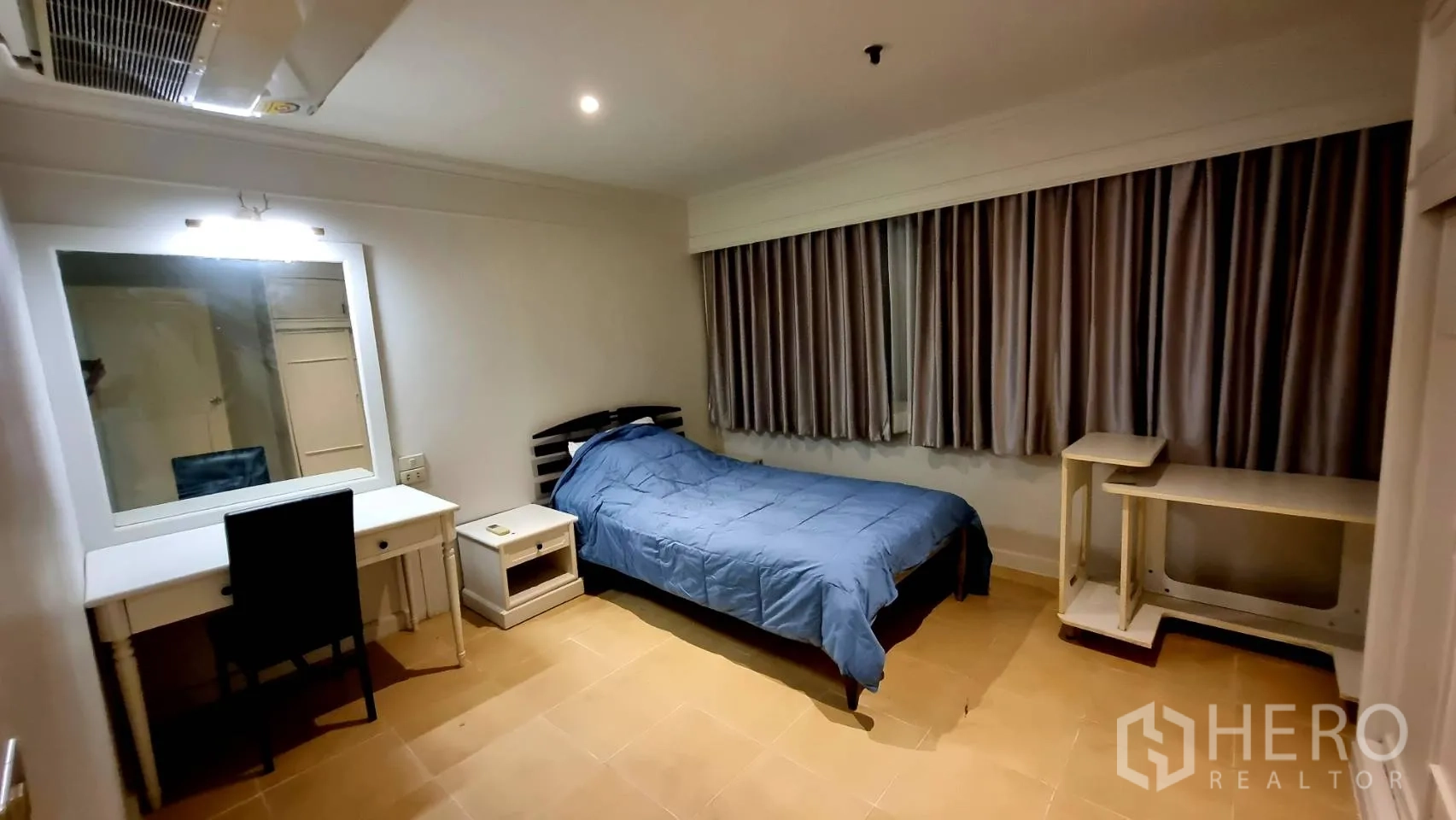 Condominium for rent in Watthana, Bangkok - Guest bedroom with single bed, desk and long curtained window.