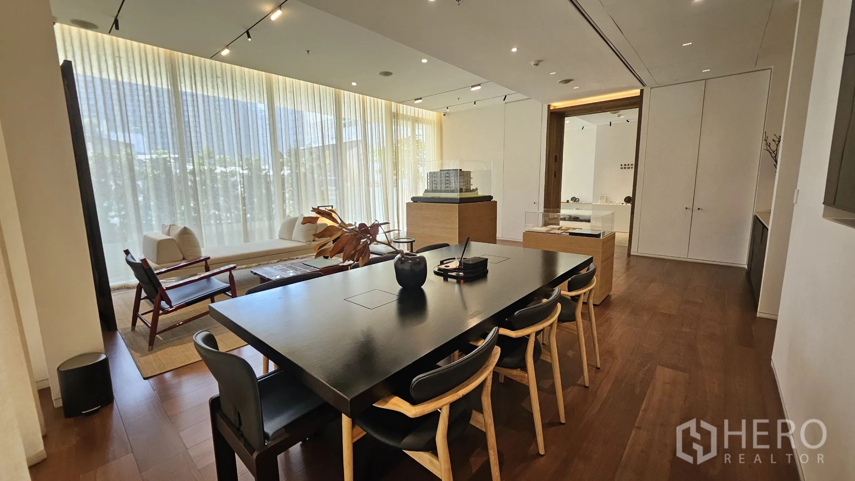 办公室 for rent in Watthana, Bangkok - 宽敞空间设黑色会议桌、会客区与靠窗展示台。