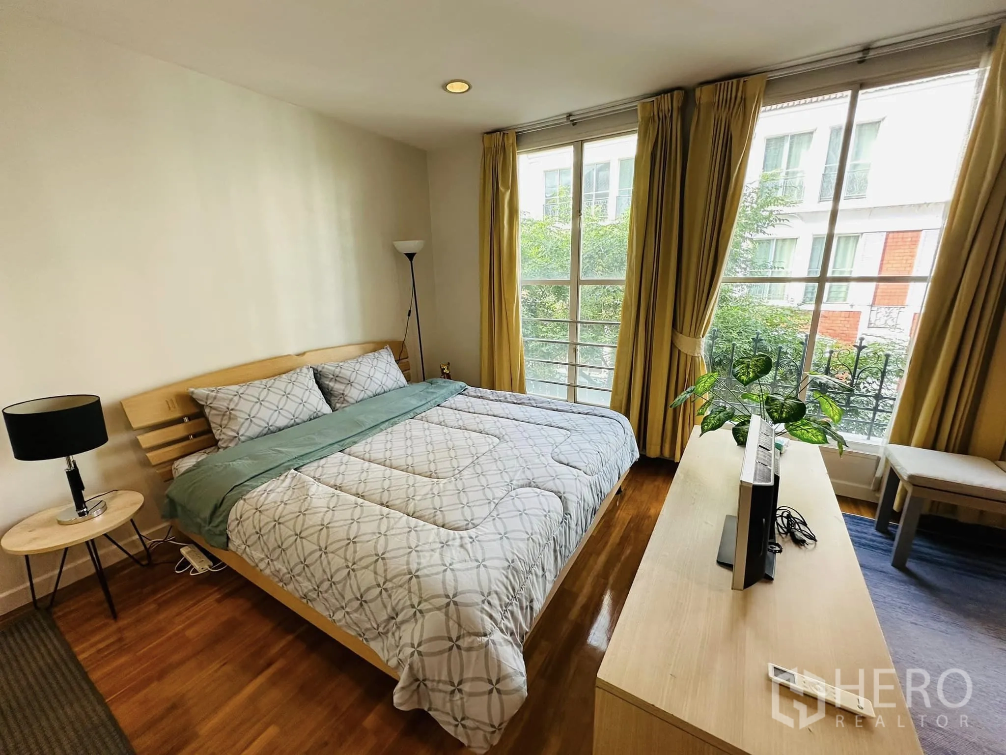 联排别墅 出租在Watthana, Bangkok - 次卧，大窗、床、电视柜与绿植