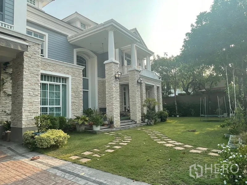 Detached House for rent in Bang Phli, Samut Prakan - Front porch with columns, stone façade and large private lawn with stepping stones.
