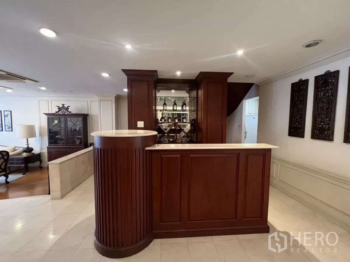 Townhouse for sale in Watthana, Bangkok - Built-in wooden bar with wine display and spotlight ceiling lights.