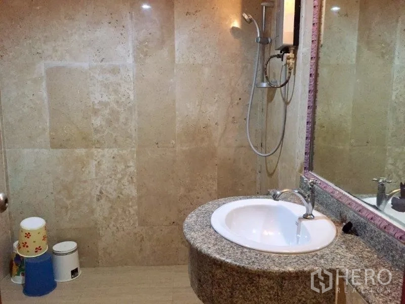 Condominium for rent or sale in Pathum Wan, Bangkok - Bathroom finished with stone-tiled walls, granite vanity and walk-in shower.