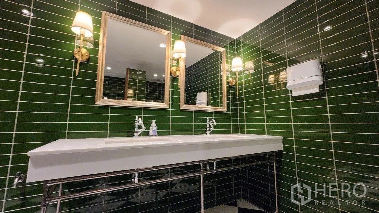 Home Office for rent in Lat Phrao, Bangkok - Double sink vanity with twin mirrors in a green tiled restroom.