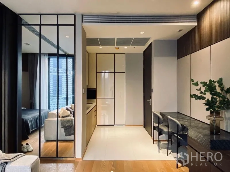 Condominium for sale - Compact kitchen with integrated fridge, cooktop and dining nook next to a glass partition.