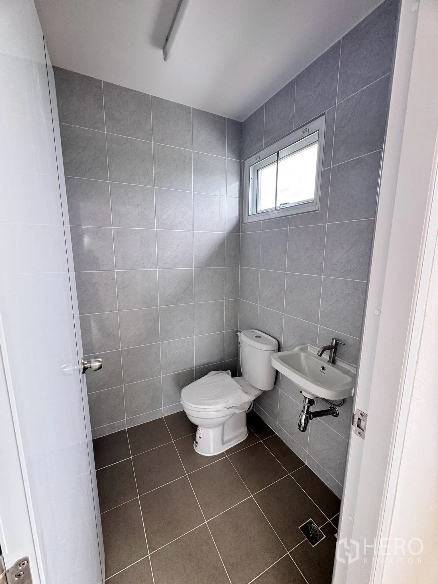 Warehouse for rent in Bang Bo, Samut Prakan - Second tiled restroom with toilet and wall-mounted sink.