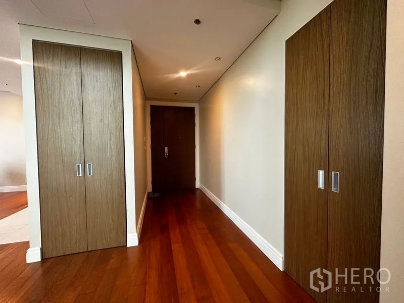 Condominium for rent in Khlong Toei, Bangkok - Entry corridor with twin built-in wardrobes and hardwood flooring.