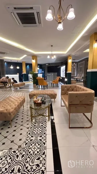 Retail Space for rent in Khlong Toei, Bangkok - Bright retail hall with coffered ceilings, pendant lights, beige sofas, and monochrome patterned tiles.