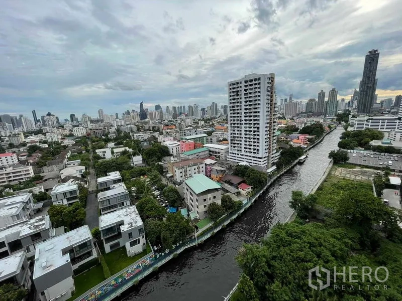 公寓 出售在Huai Khwang, Bangkok - 高楼阳台远眺运河、绿色社区与曼谷天际线。