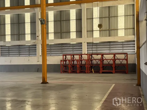 Factory for rent or sale in Bang Phli, Samut Prakan - Open production area with crane hook and red steel racks along the wall.