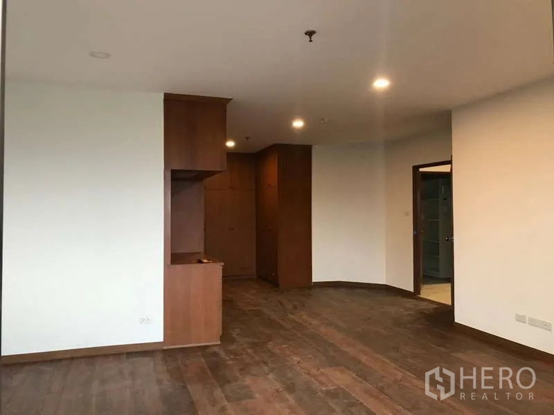 公寓 出售在Watthana, Bangkok - 开放空间，木质柜体、筒灯与通往卧室的走廊。