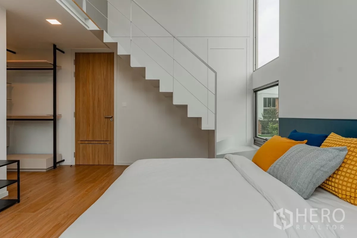 Detached House for rent in Saphan Sung, Bangkok - Duplex bedroom with staircase to mezzanine and colorful cushions.