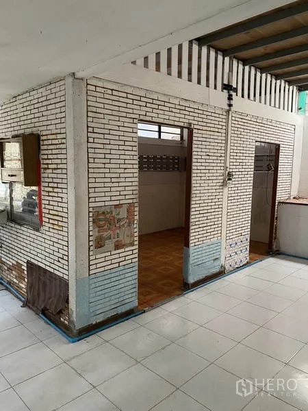 Townhouse for rent in Lat Phrao, Bangkok - Semi-open area with white painted brick partitions and tiled flooring.