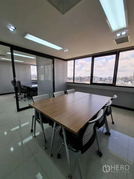 Office Space for rent - Bright meeting room with large windows and city skyline views in a Bang Rak office near BTS Sala Daeng.