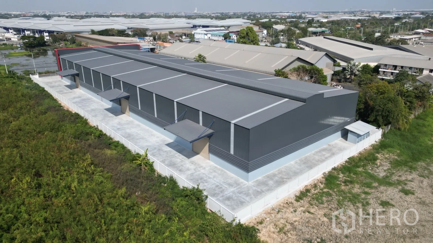 Warehouse for rent in Mueang Samut Prakan, Samut Prakan - Aerial side view of the warehouse showing loading bays and wide circulation roads.