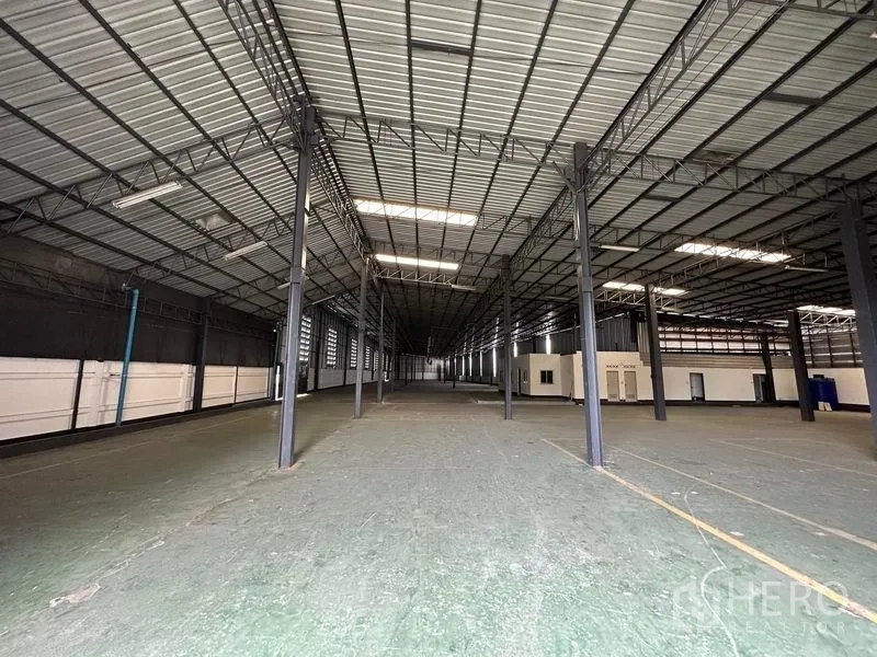 Warehouse for rent in Khan Na Yao, Bangkok - Expansive high‑ceiling warehouse interior with steel columns, skylights and a wide open floor.
