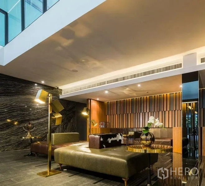 公寓 出租或出售在Watthana, Bangkok - 时尚大堂休息区，皮质沙发与设计师灯饰。