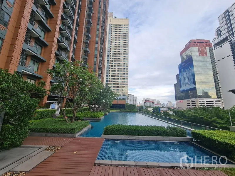 公寓 出售在Ratchathewi, Bangkok - 公寓户外泳池与木平台，绿化和城市天际线