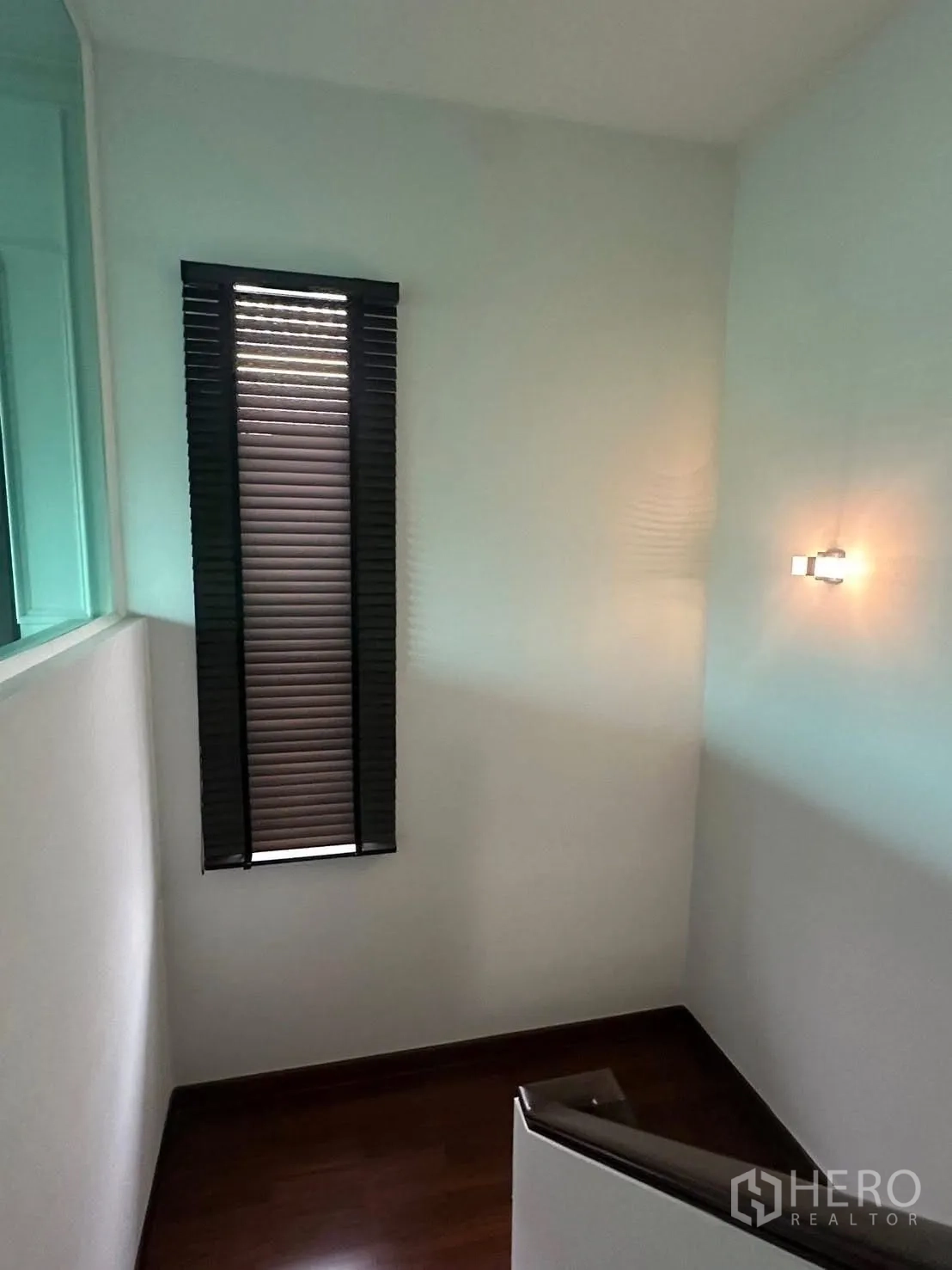 独立式住宅 出租在Lat Krabang, Bangkok - 楼梯平台，窄长窗与墙面壁灯。
