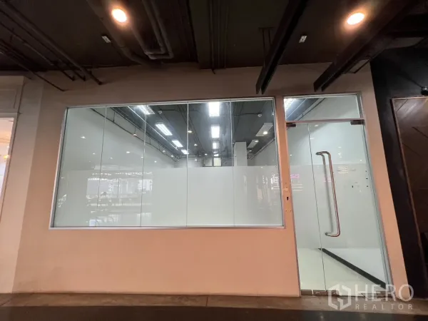 Retail Space for rent - Full-height glass storefront with display window and glass door inside an indoor mall.