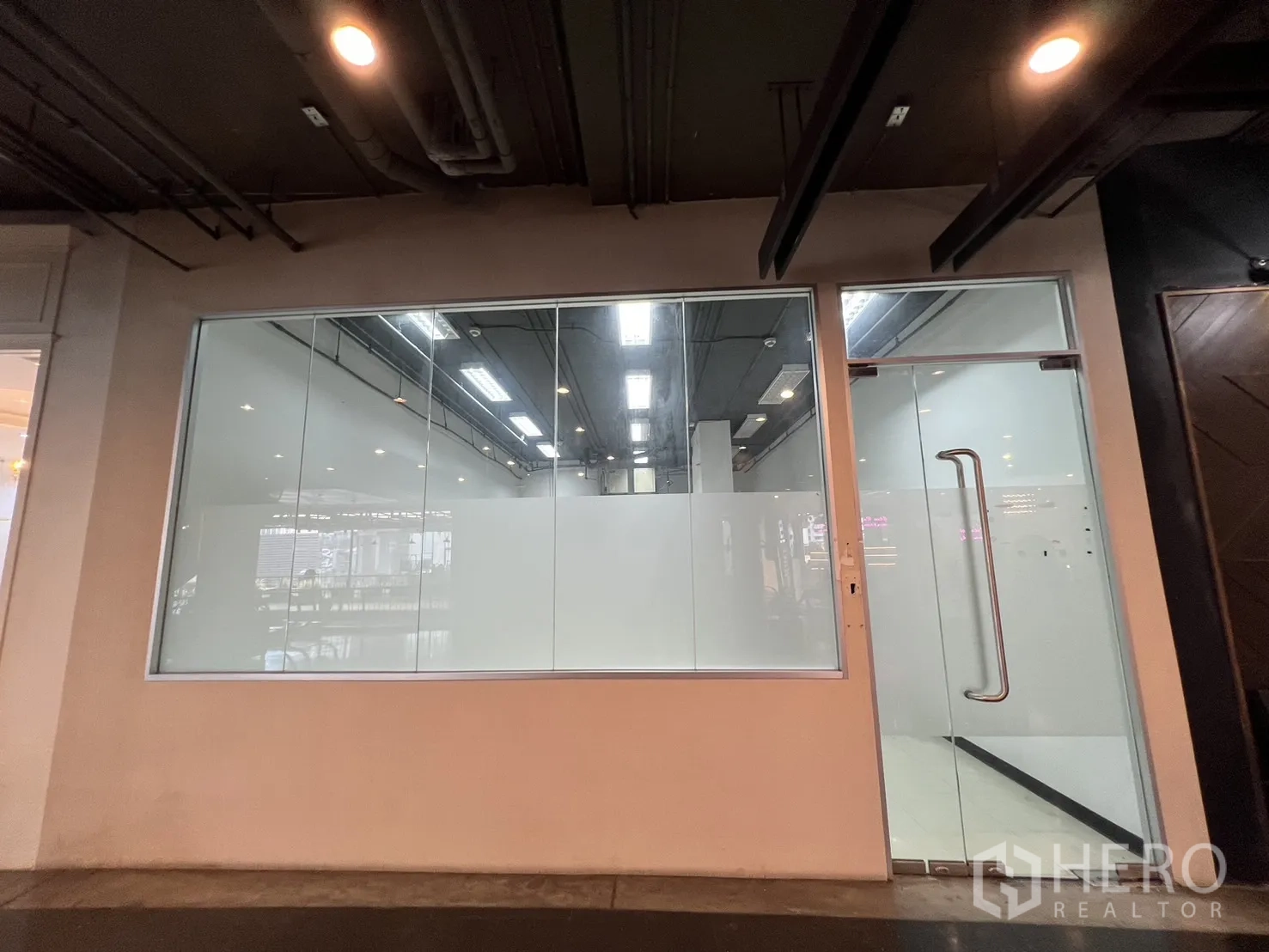 Retail Space for rent - Full-height glass storefront with display window and glass door inside an indoor mall.