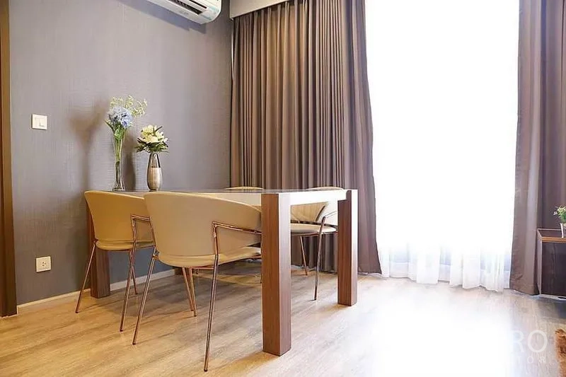 公寓 出租在Huai Khwang, Bangkok - 采光良好的用餐角，木质餐桌、两把椅子与大窗户。
