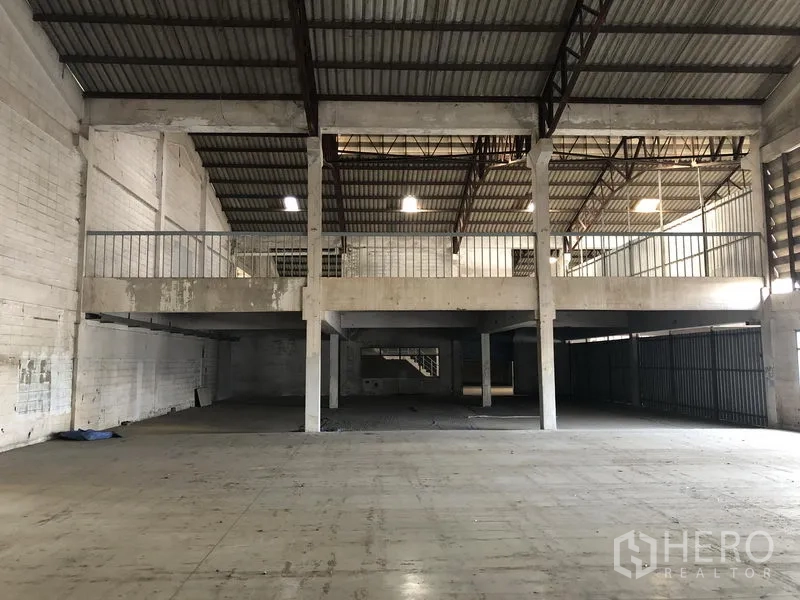 Factory for rent in Lam Luk Ka, Pathum Thani - Mezzanine storage platform inside the factory with lighting under a metal roof.