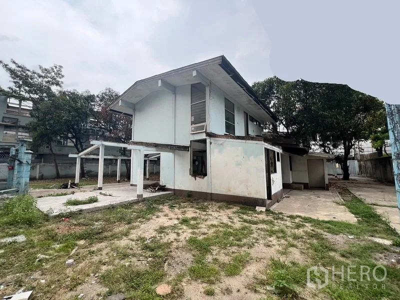 Land for rent in Watthana, Bangkok - Vacant two-storey house structure standing on open ground within the compound.