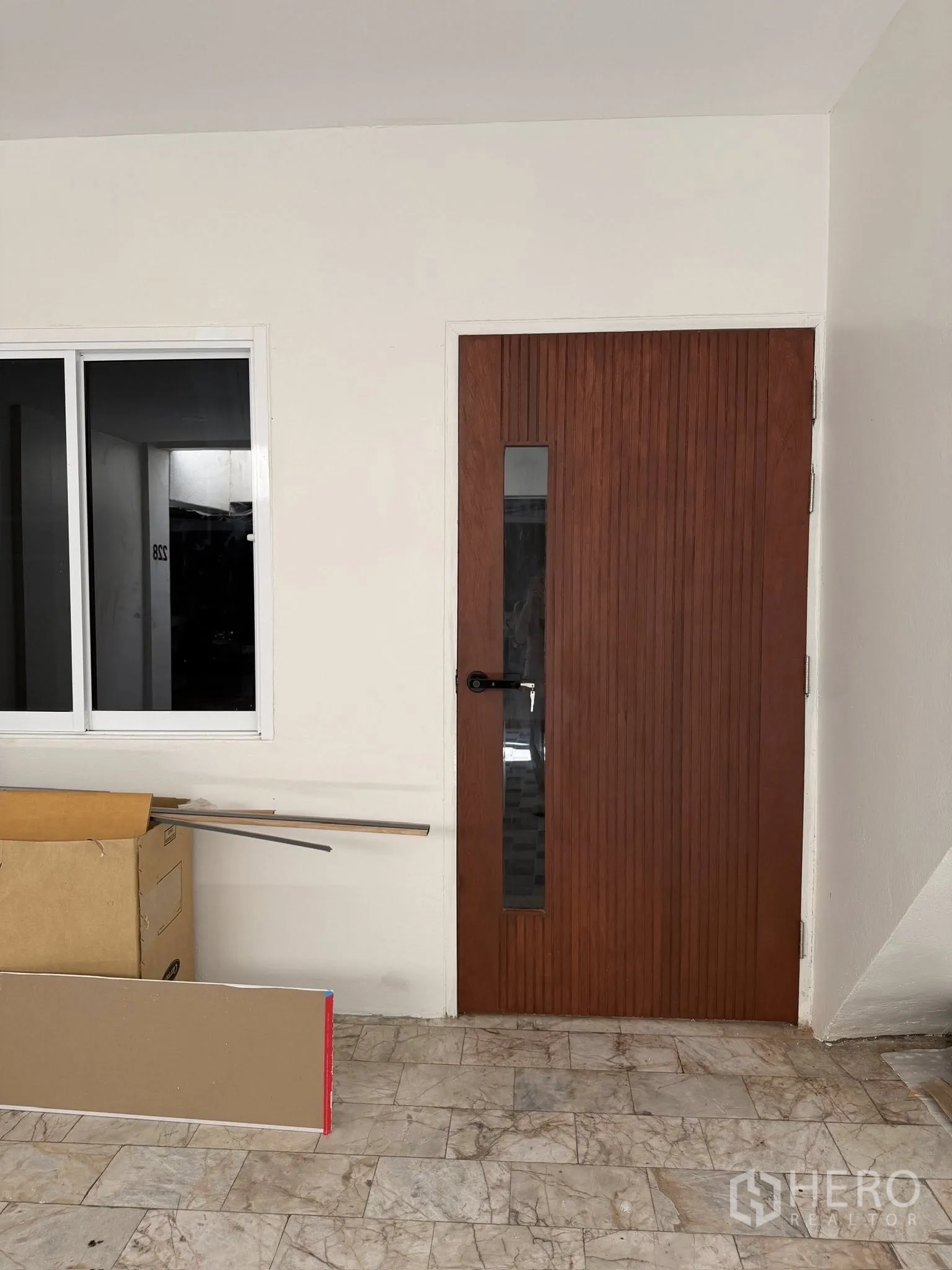 Townhouse for rent or sale in Yan Nawa, Bangkok - Entrance area with wood door, sliding window, and stone-tiled floor.