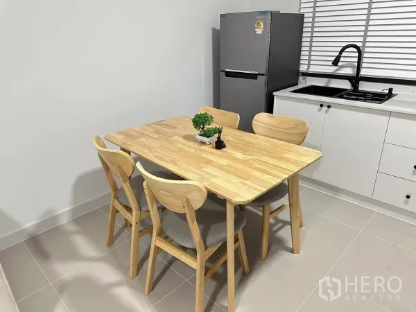 Townhouse for rent in Bang Phli, Samut Prakan - Close‑up of the wooden dining set beside a refrigerator and window sink.