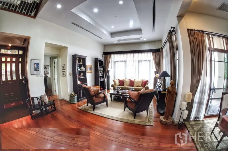 Detached House for rent in Watthana, Bangkok - Cozy living room with recessed ceiling, full-height windows and built-in shelving.