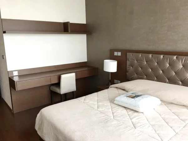 公寓 出租在Watthana, Bangkok - 主卧有软包床头、木地板与内置书桌。