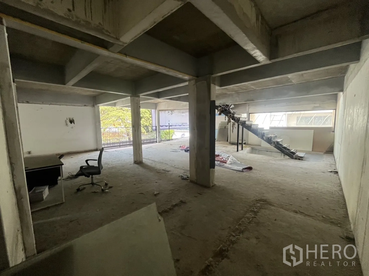 Retail Space for rent in Watthana, Bangkok - Spacious shell unit featuring a central metal staircase and broad window openings.