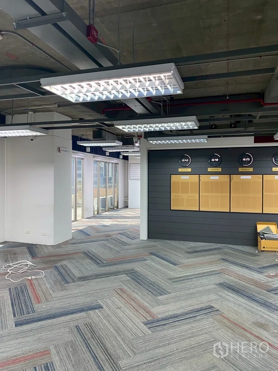 ออฟฟิศ for rent in Watthana, Bangkok - โถงทำงานโล่งมีผนังตกแต่งติดนาฬิกา ข้างประตูทางออกสู่ระเบียง