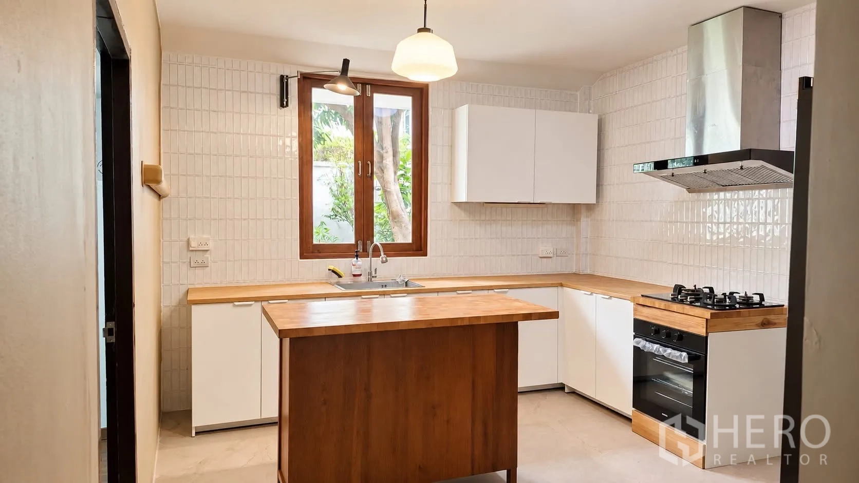 บ้านเดี่ยว for rent in Khlong Toei, Bangkok - มุมครัวที่มีเตาแก๊ส เตาอบ ผนังกระเบื้อง และเกาะกลาง