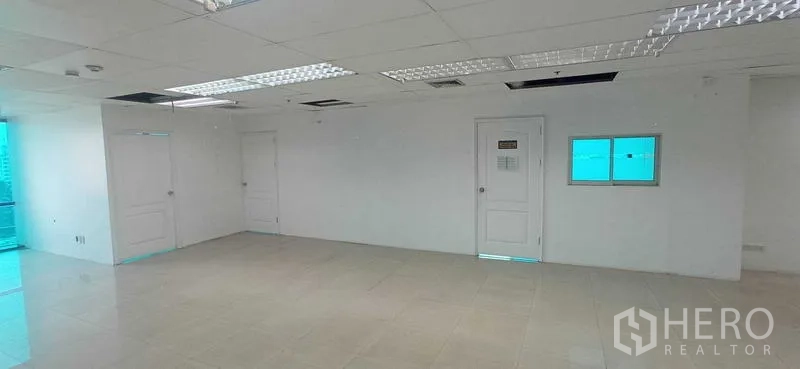 สำนักงาน ให้เช่าในHuai Khwang, Bangkok - ผนังสำนักงานพร้อมประตูสองบานและช่องหน้าต่างภายในใต้ฝ้าแบบกริด.