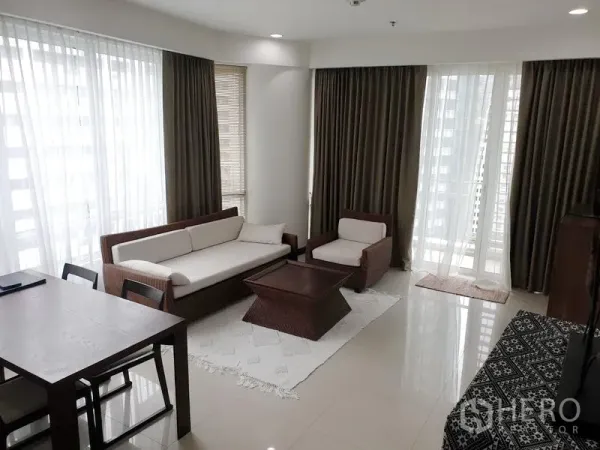 公寓 出租或出售在Pathum Wan, Bangkok - 采光充足的客厅，落地窗、米色沙发组合，可通往阳台的曼谷公寓。